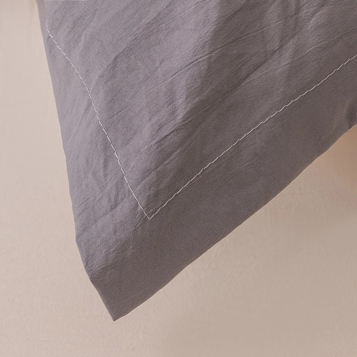 Détail de la bordure cousue de la taie de traversin gris