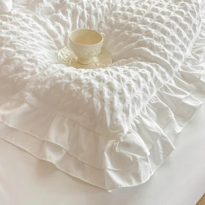 Détail du tissu seersucker gaufré et du volant de la parure de lit
