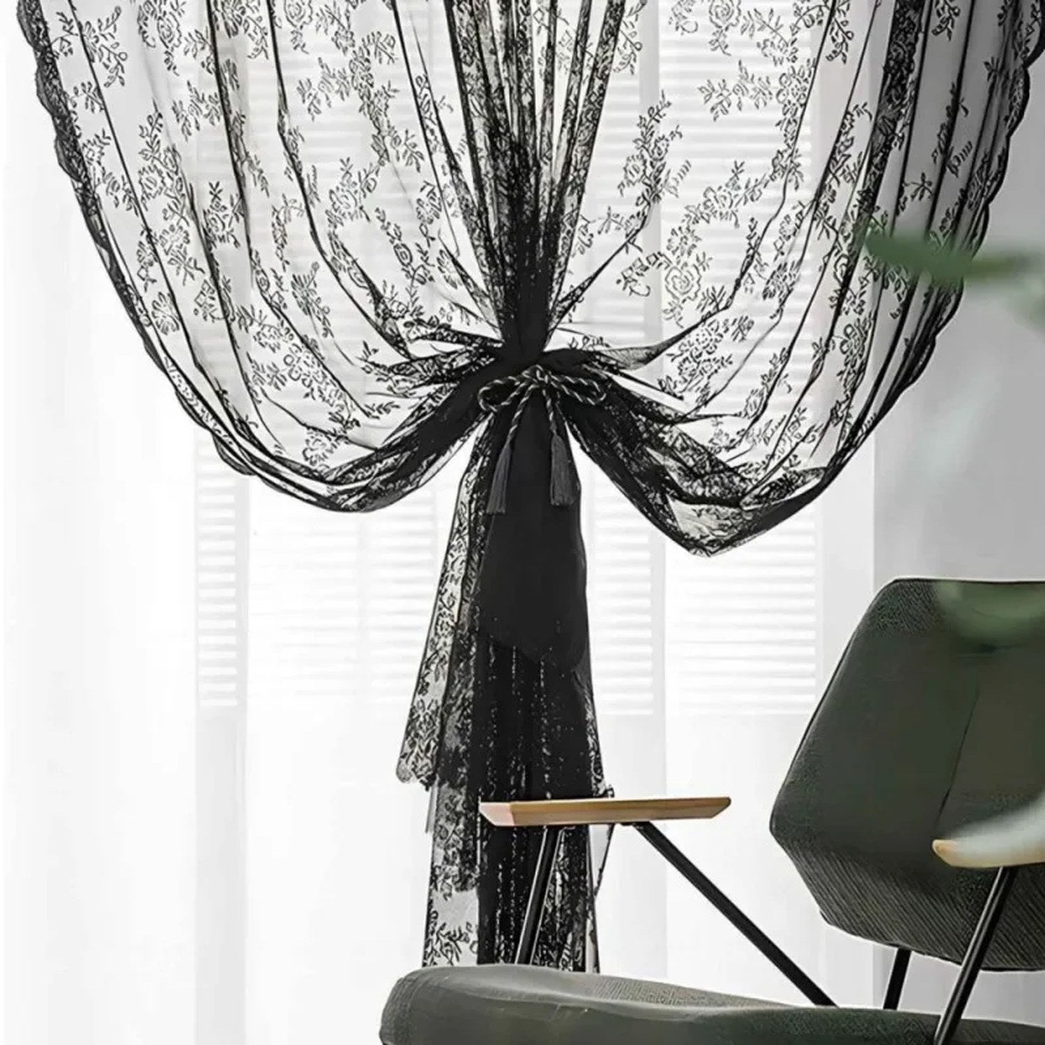 Rideau en dentelle noire à motif floral retenu par une embrasse à pompon