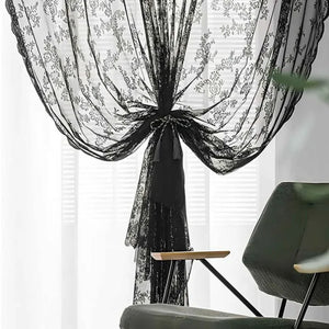 Rideau en dentelle noire à motif floral retenu par une embrasse à pompon