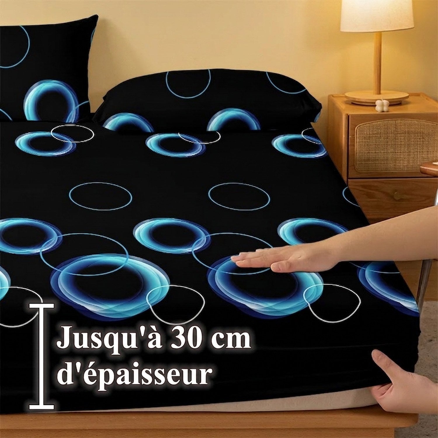 Main soulevant le coin élastiqué du drap-housse jusqu'à 30 cm d'épaisseur de matelas