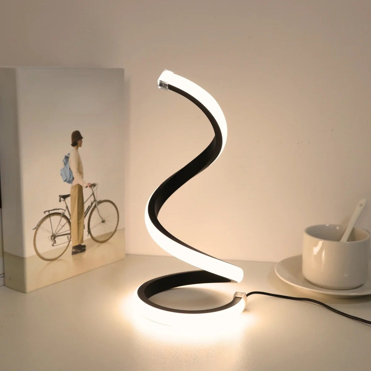 Lampe spirale LED en lumière chaude à côté d'un cadre photo et d'une tasse