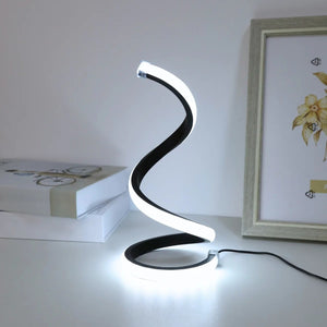 Lampe spirale LED en lumière blanche froide posée sur un bureau