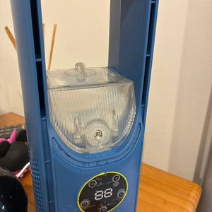 Ventilateur humidificateur bleu posé sur une table en bois