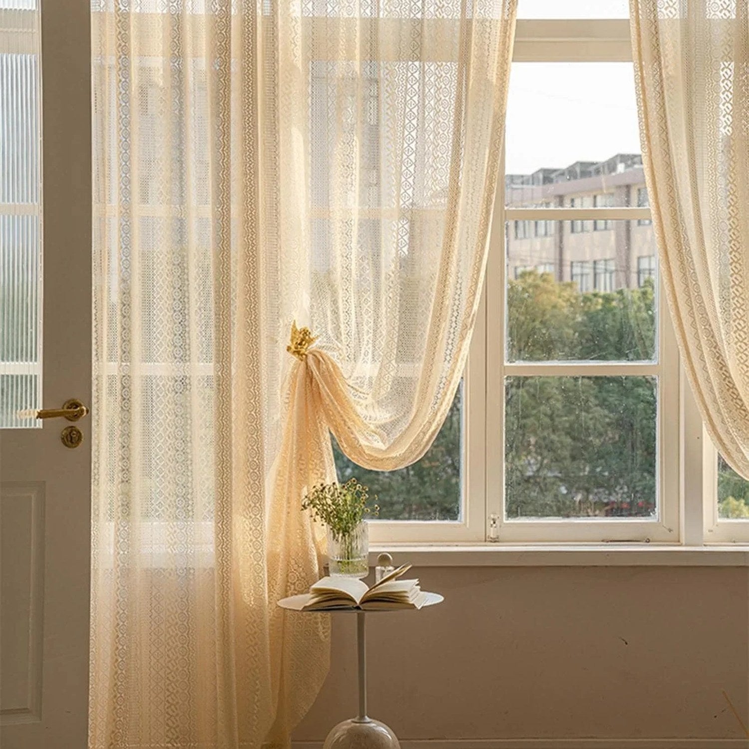 Voilage beige noué embellissant une grande fenêtre dans un salon ensoleillé