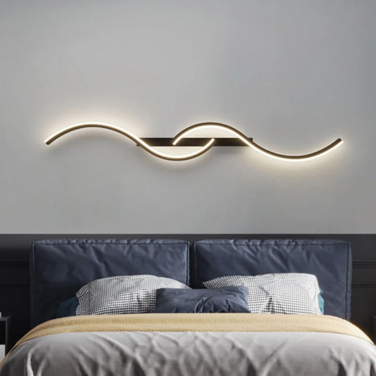 Applique murale LED noire posée à l'horizontale au-dessus d'un lit