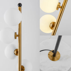 Détail des boules de verre blanc laiteux et des fixations dorées du lampadaire nordique
