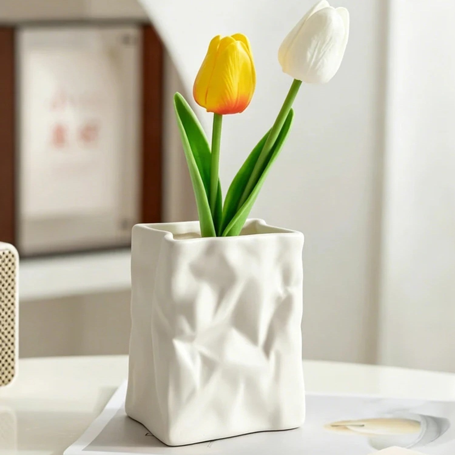 Vase style sac en papier froissé blanc avec roses sur table ronde