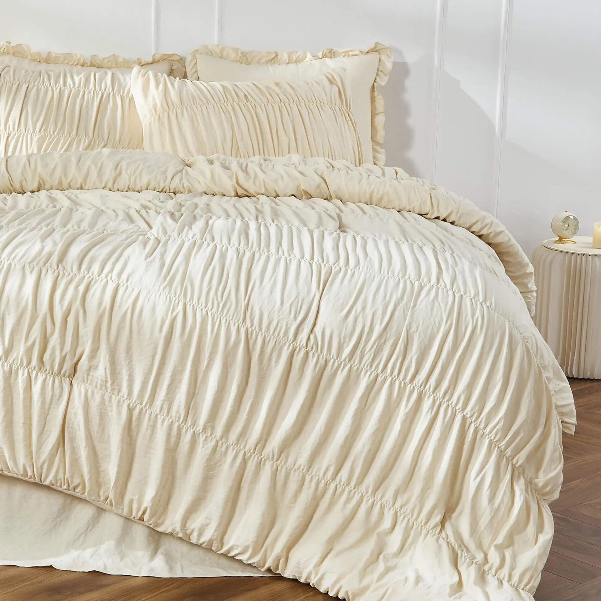 Parure de lit bohème chic beige posée sur un lit dans une chambre épurée au sol en bois