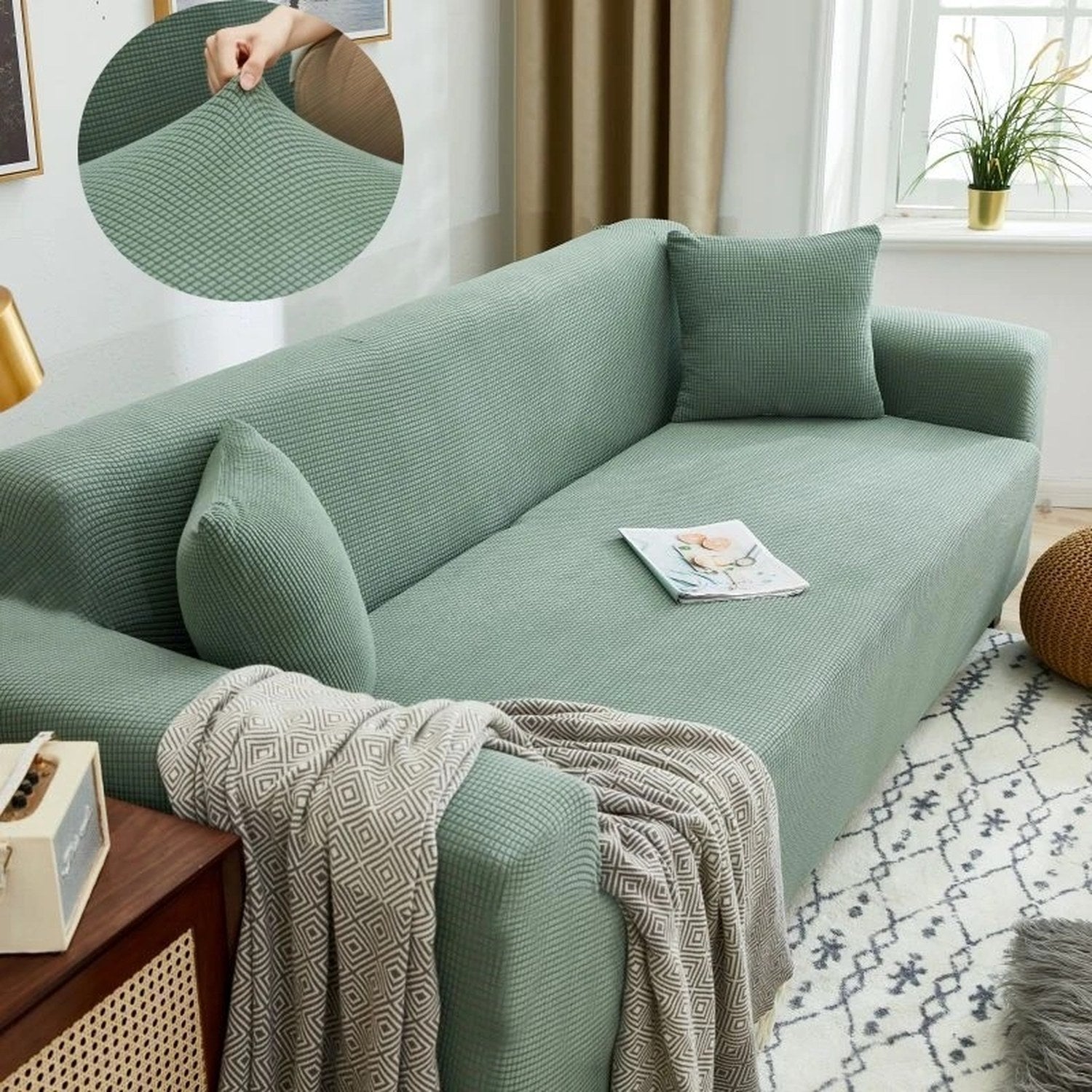 Housse de canapé extensible verte sur un canapé droit avec plaid et coussins