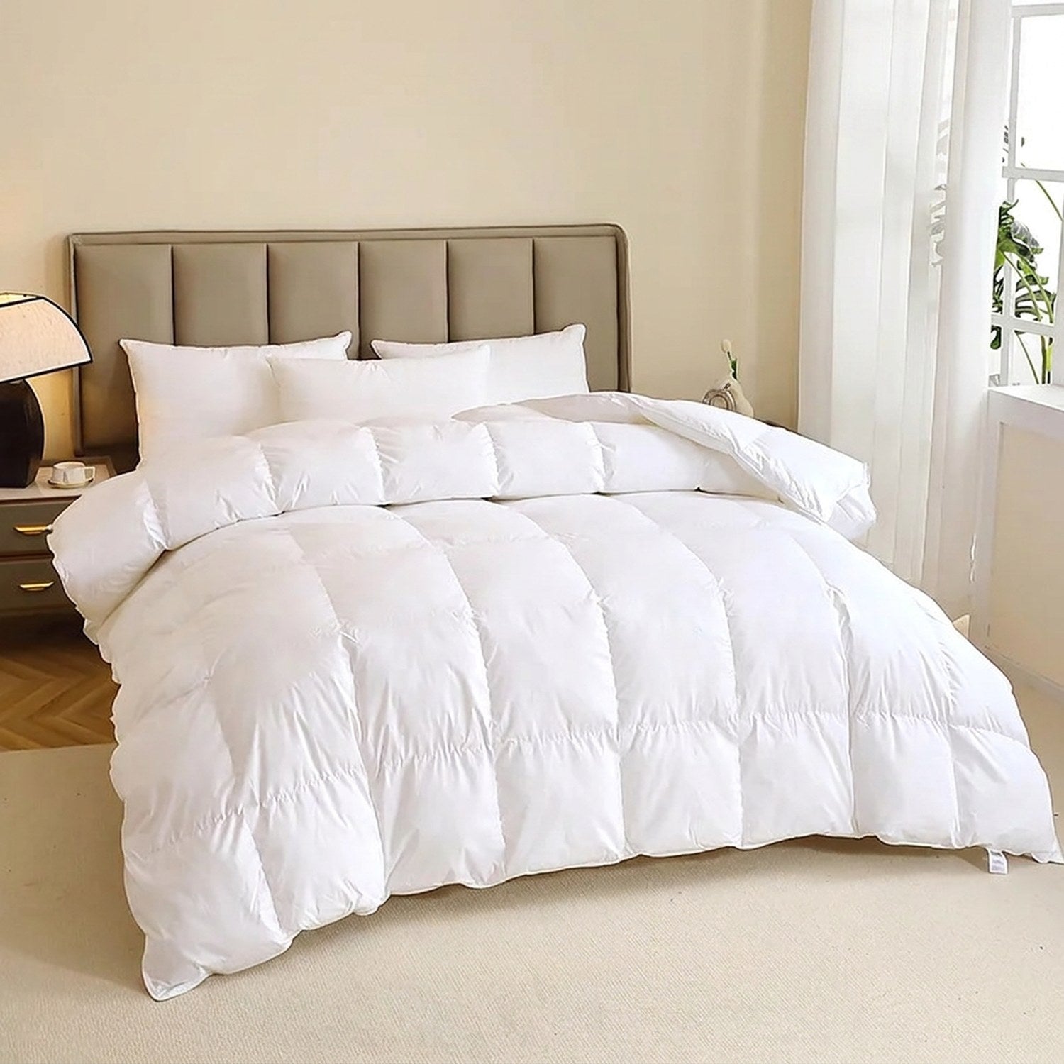 Couette en duvet d'oie blanche posée sur un lit avec oreillers moelleux