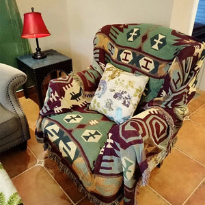Jeté de canapé bohème motif vert et bordeaux posé sur un fauteuil
