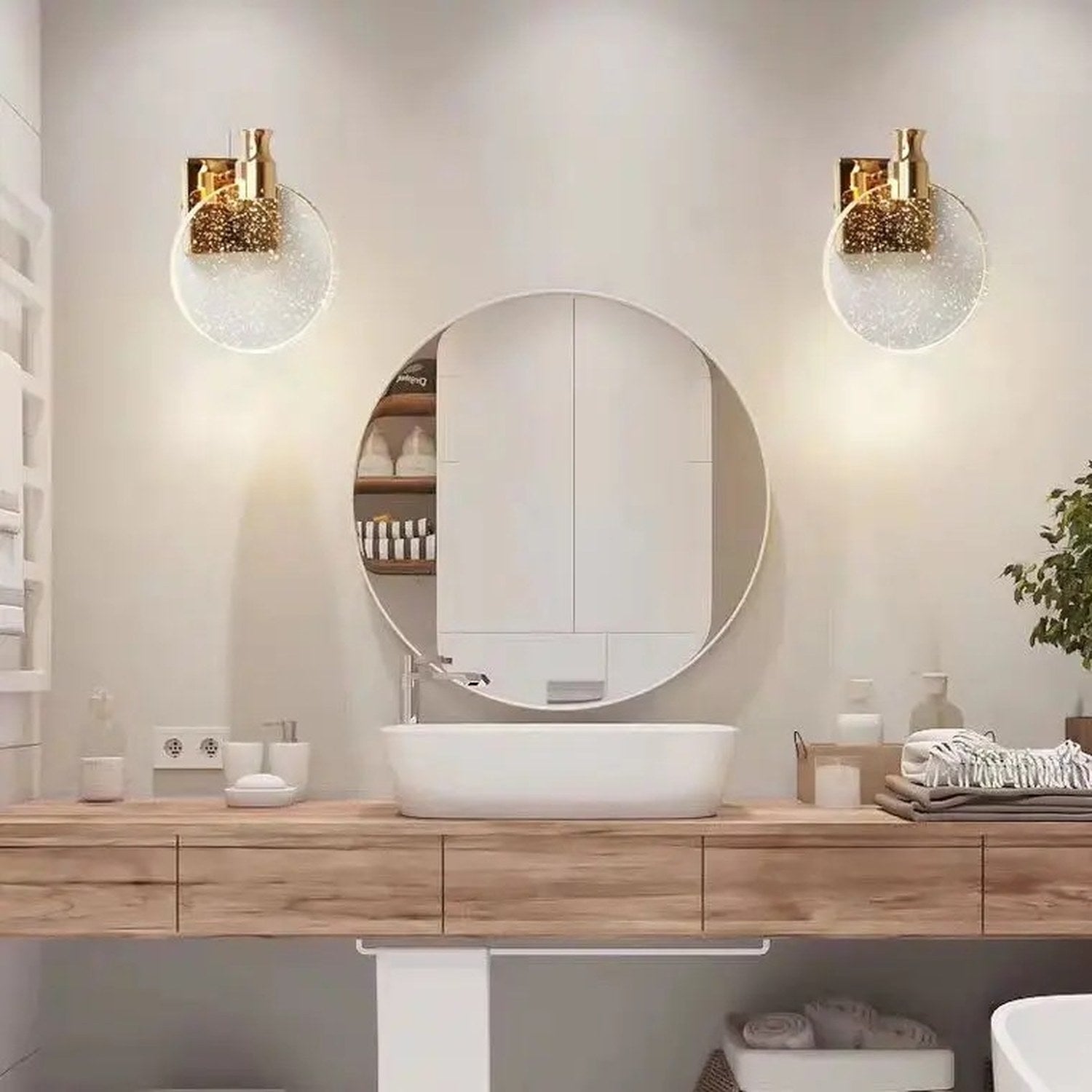 Applique murale dorée installée près d'un miroir rond dans une salle de bain
