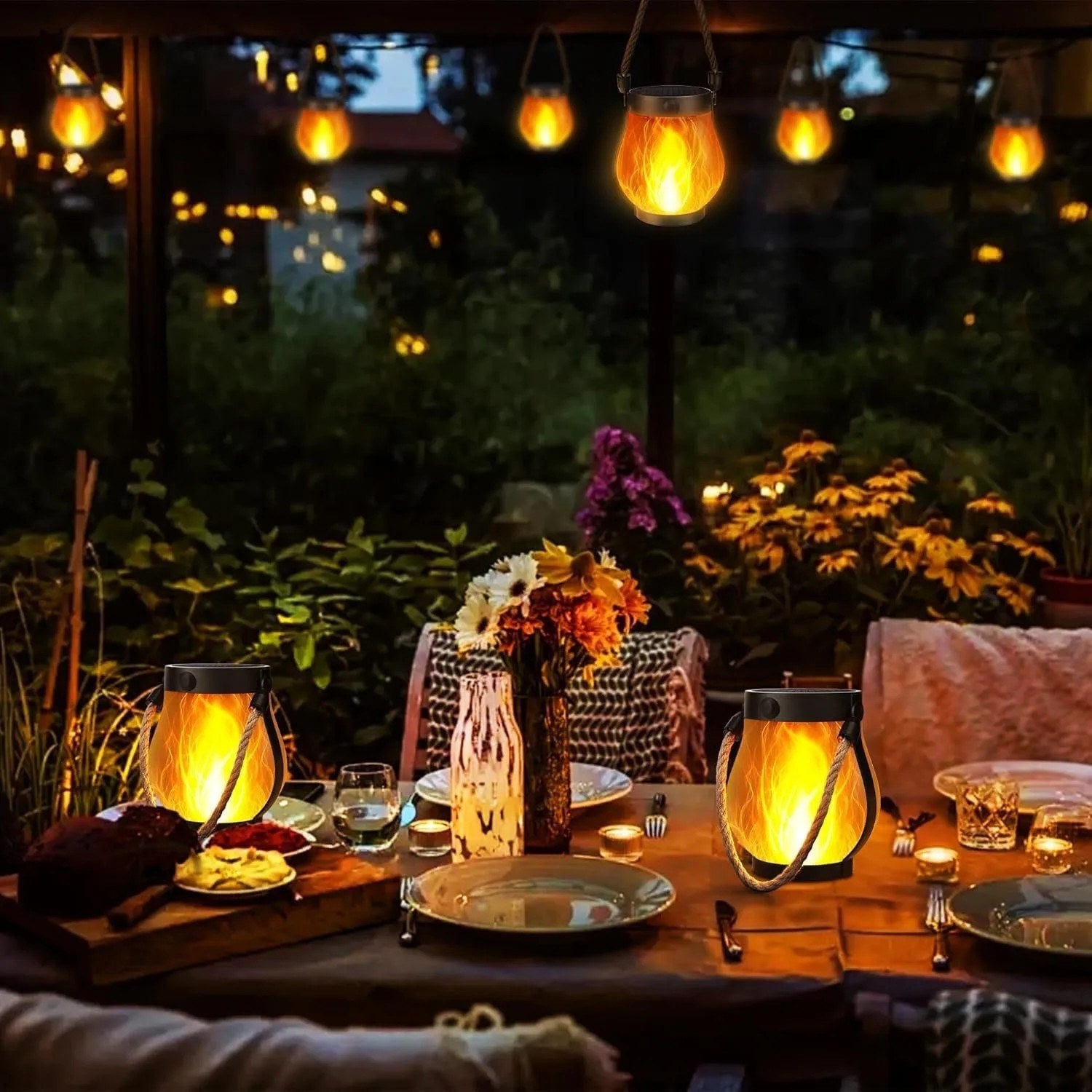 Lanternes solaires à flamme sur une table de dîner en extérieur, ambiance soirée d'été