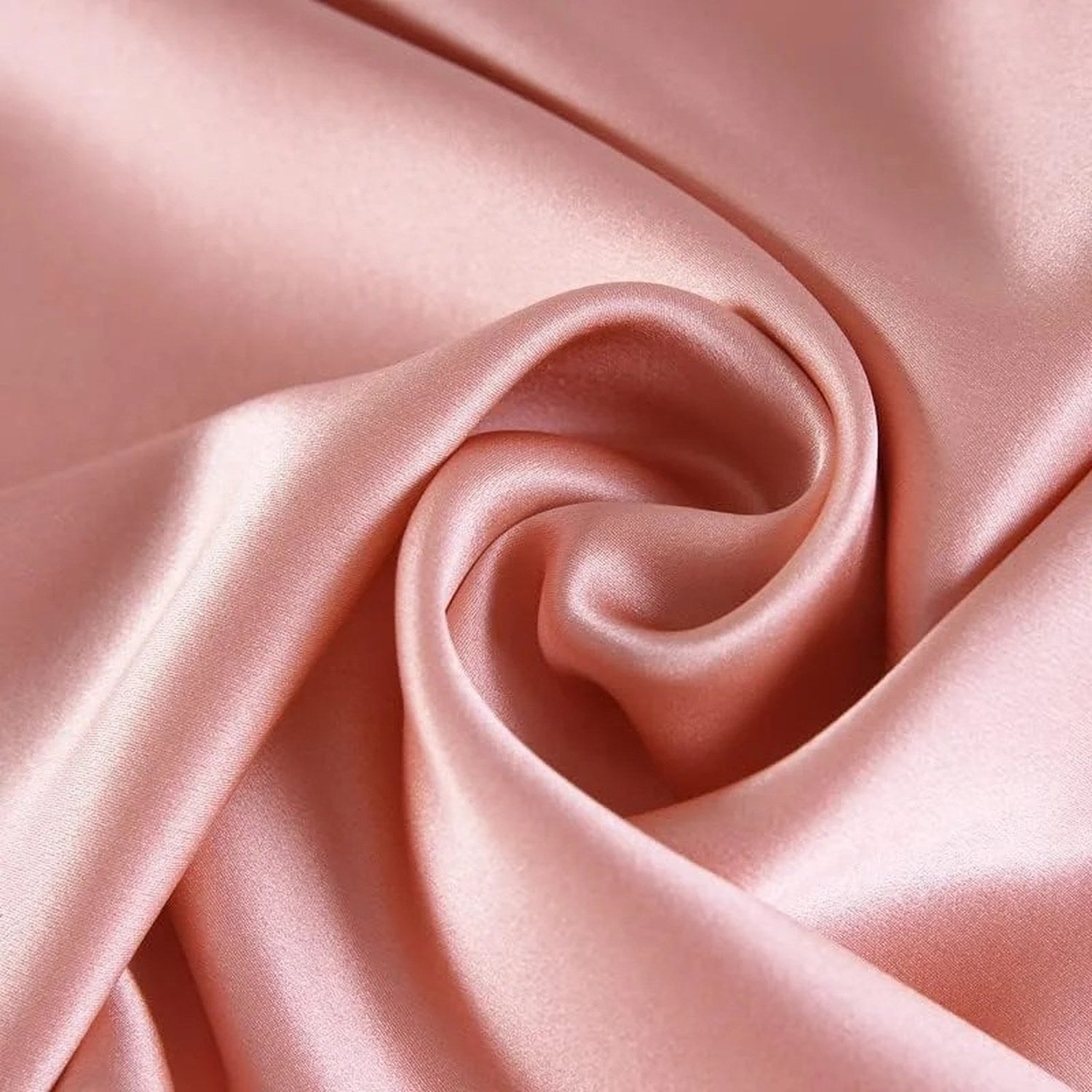 Gros plan sur le tissu de soie rose poudré froissé de la taie d'oreiller