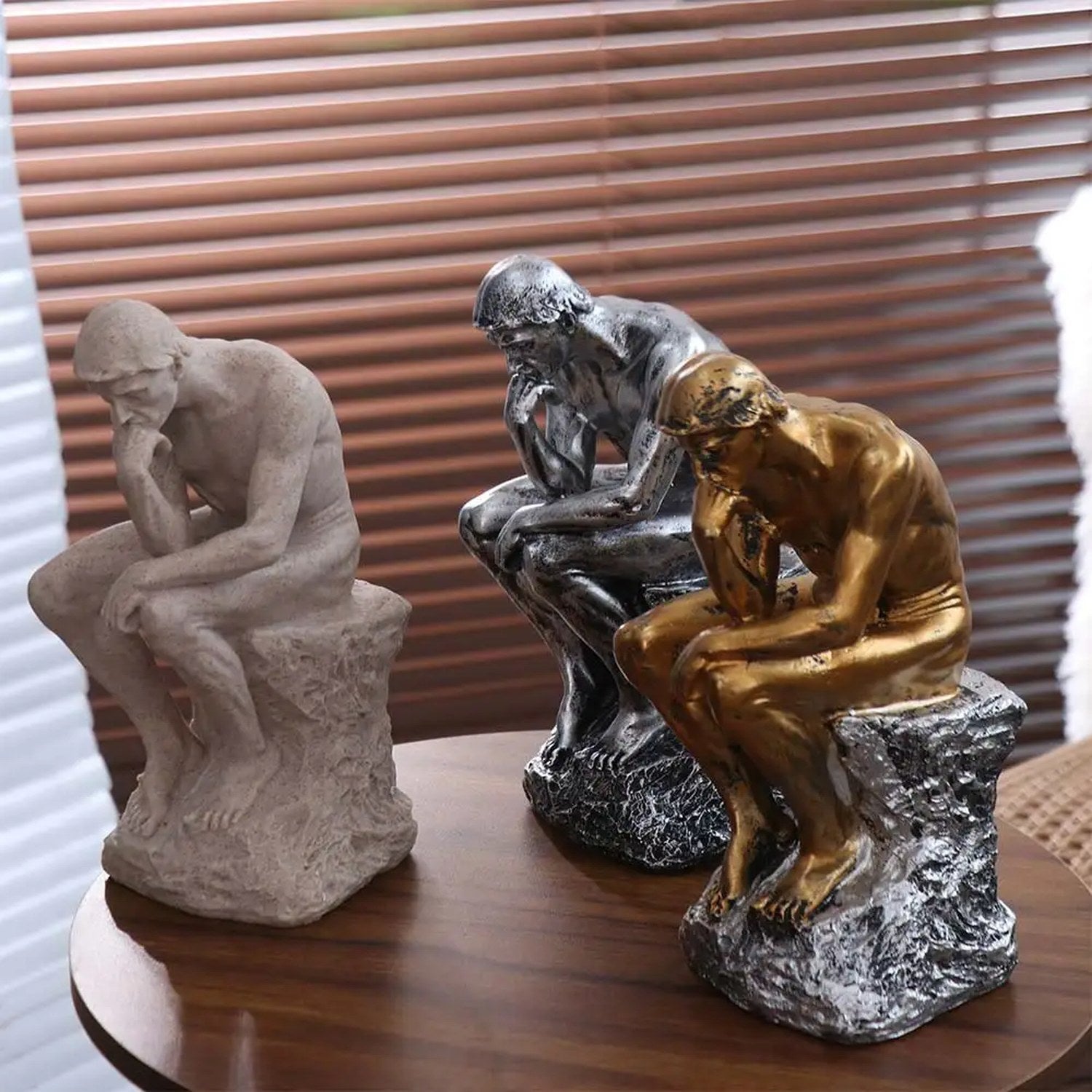 Statue Le Penseur de Rodin présentée dans ses trois finitions beige argentée et dorée