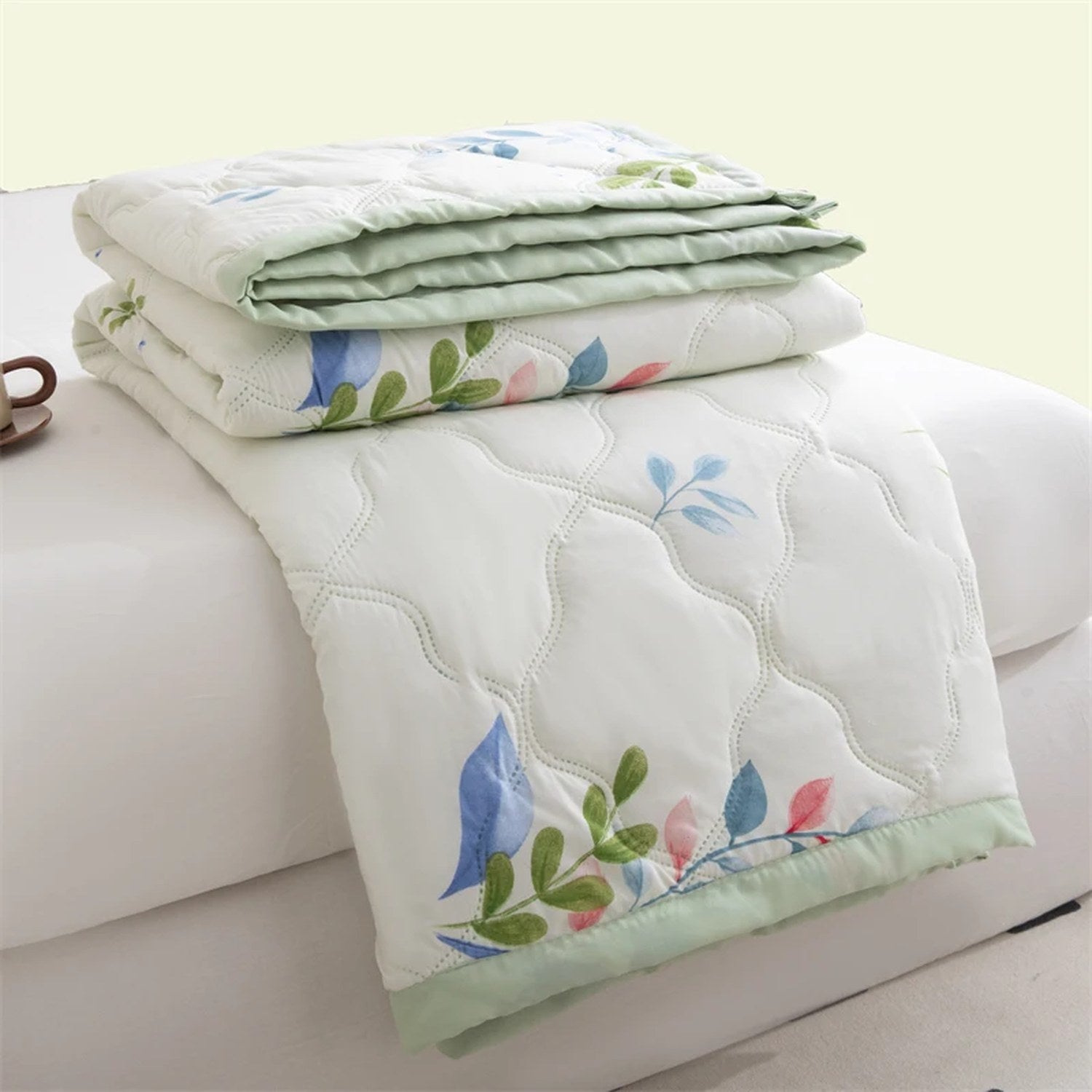 Couverture d'été pliée à motif feuillage vert et rose