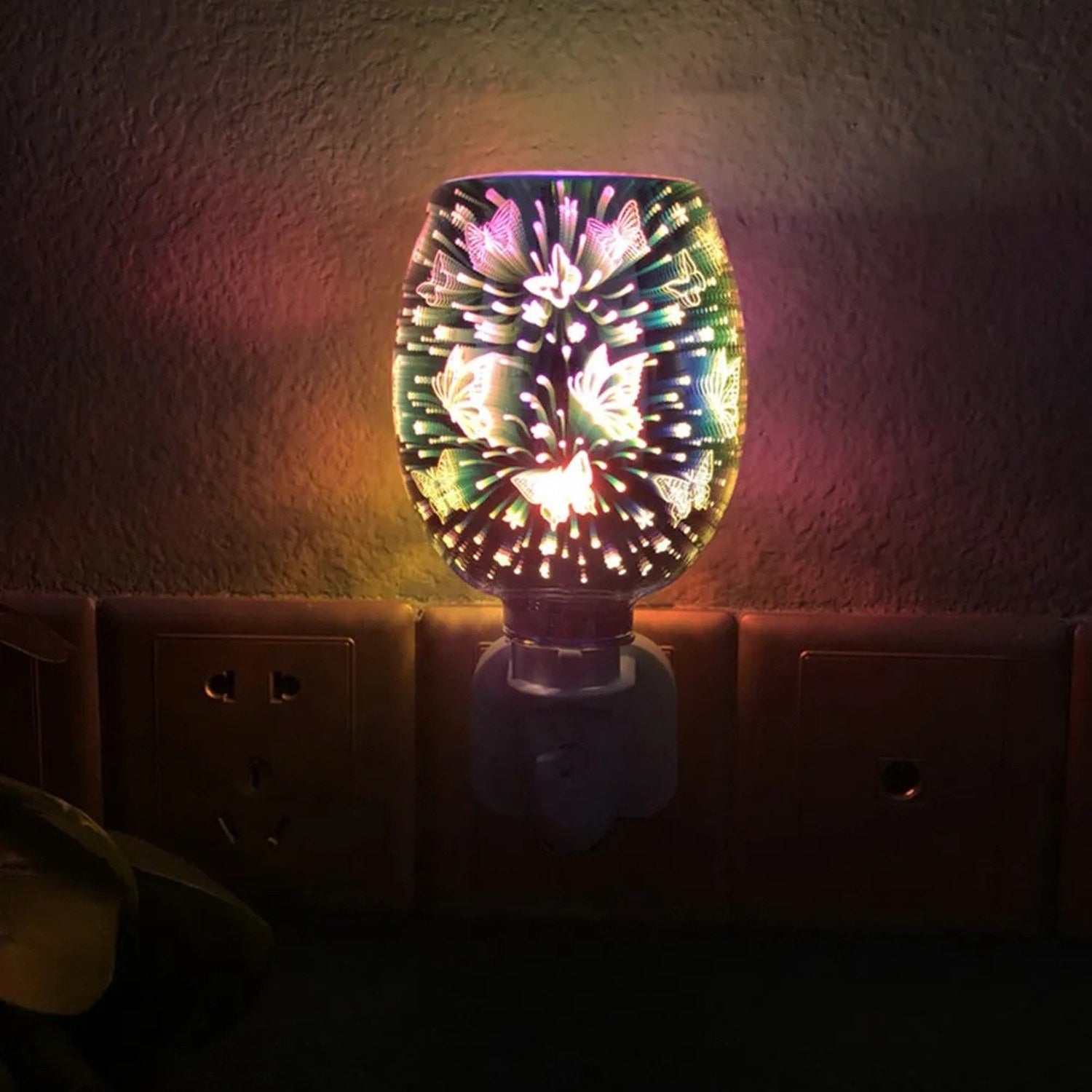 Brûle-parfum électrique branché sur une prise murale dans une pièce sombre