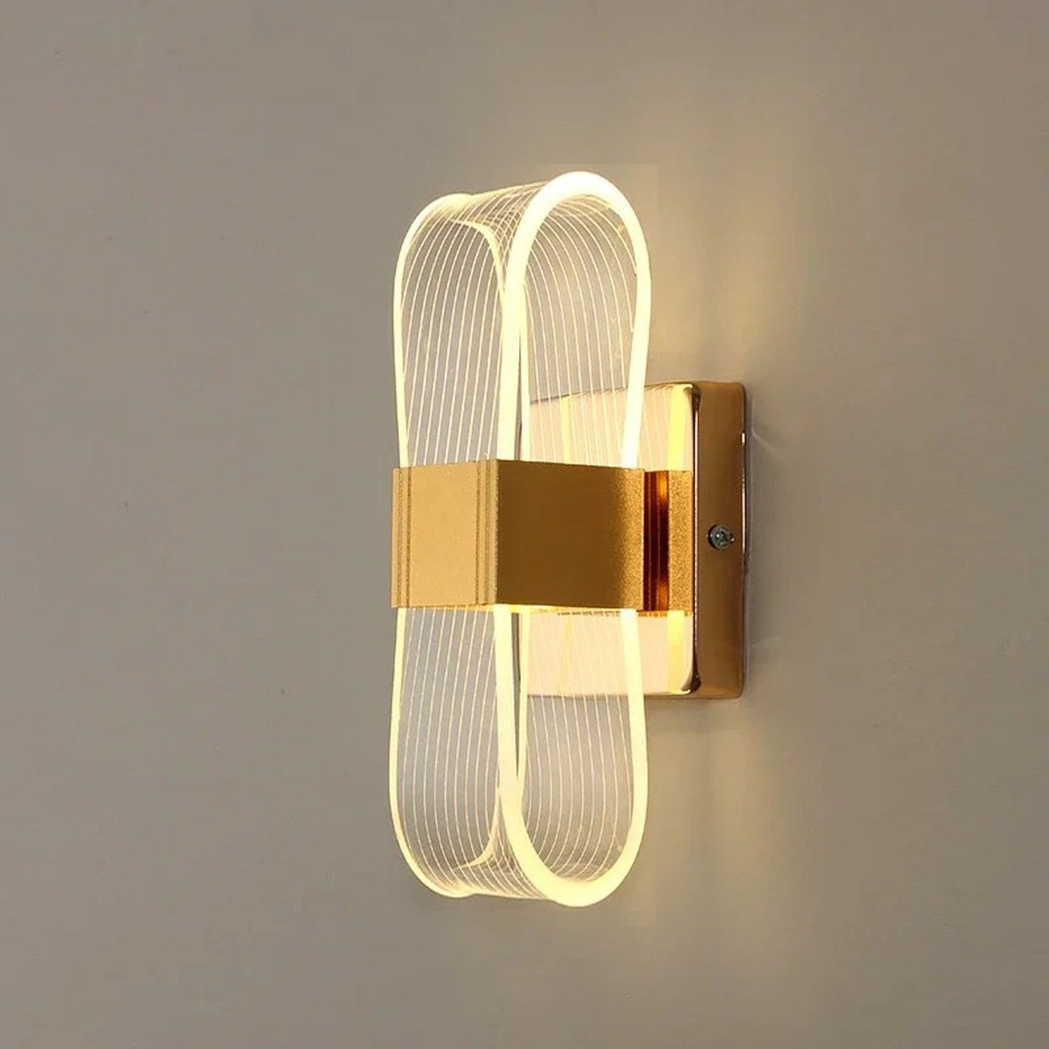 Applique murale dorée au design ruban lumineux vue de face sur fond neutre