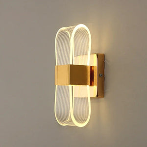 Applique murale dorée au design ruban lumineux vue de face sur fond neutre