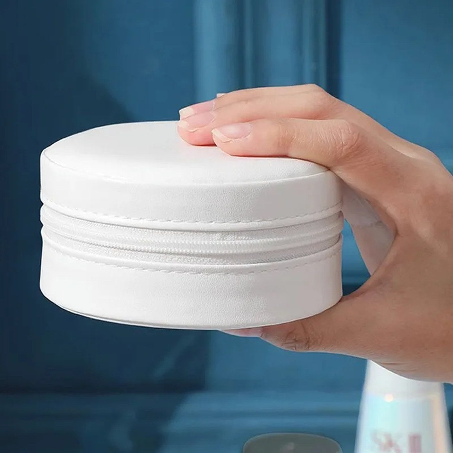 Coffret à bijoux de voyage blanc fermé tenu en main, compact et léger