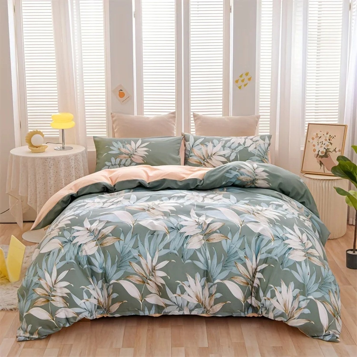 Parure de lit feuilles tropicales verte et pêche avec housse de couette et deux taies sur un lit
