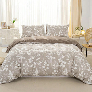 Parure de lit feuillage taupe et blanc avec housse de couette et deux taies assorties sur un lit fait