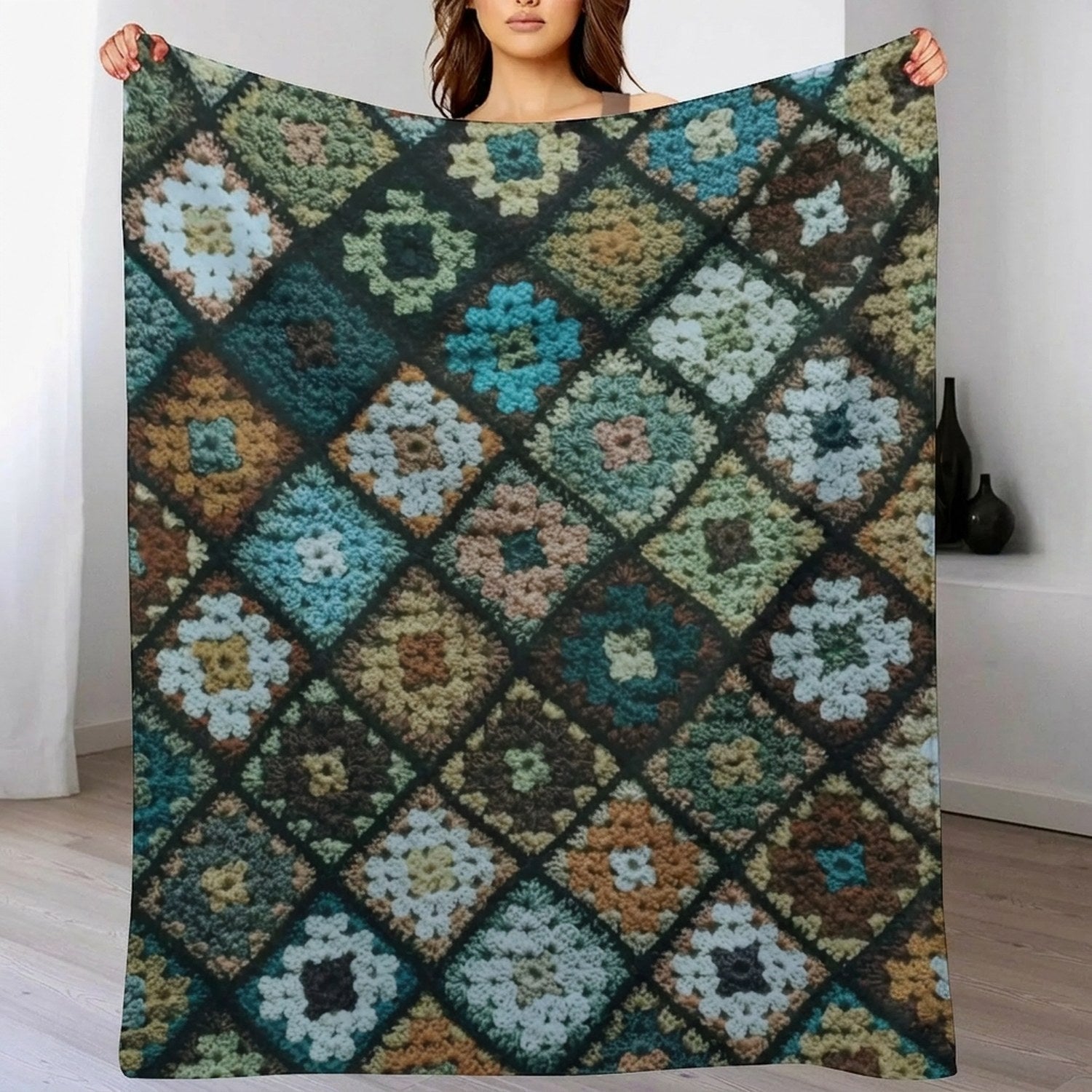 Plaid patchwork multicolore effet crochet déplié tenu à la main devant un mur clair