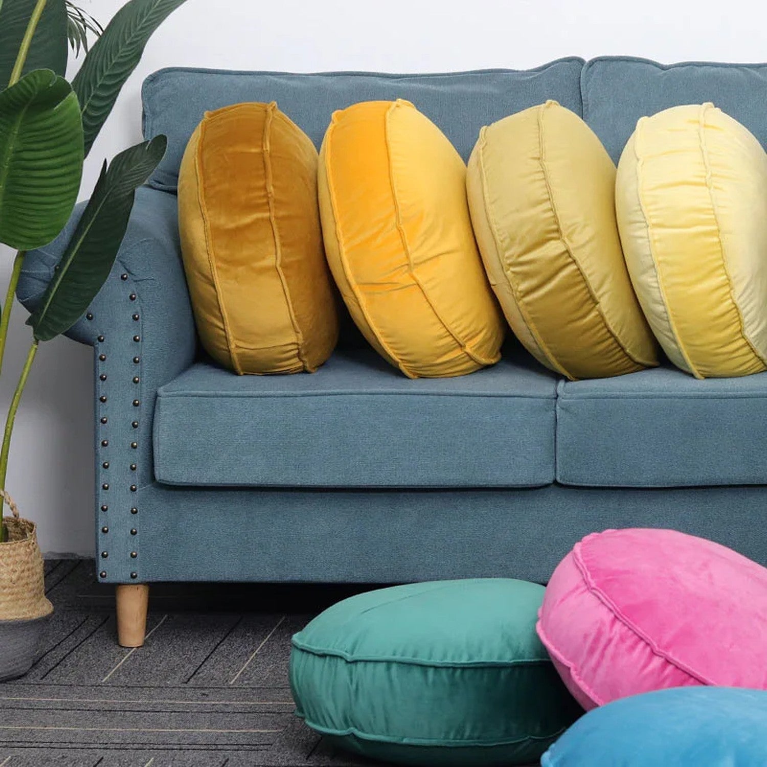 Coussins ronds en velours de plusieurs coloris disposés dans un salon