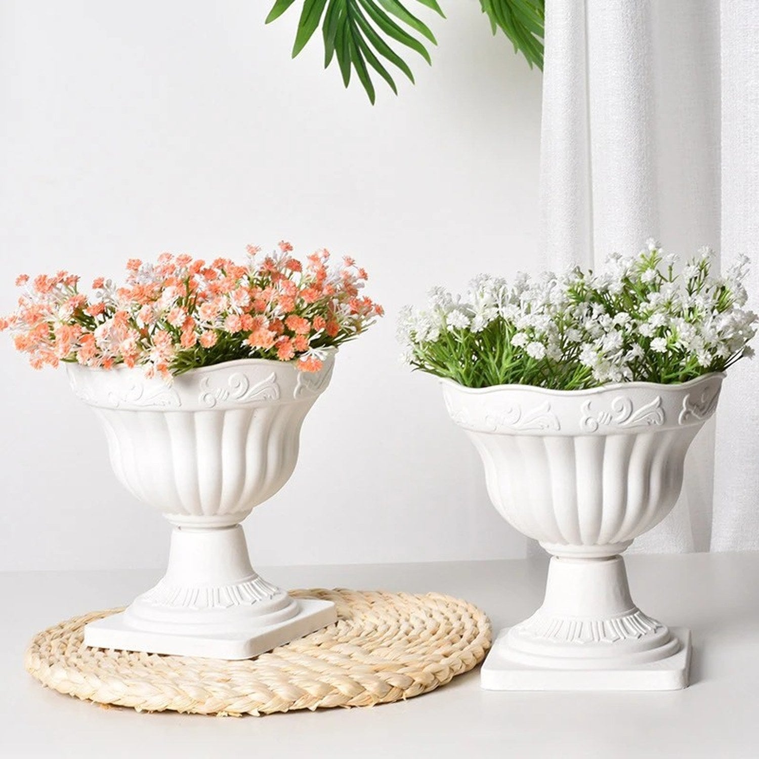 Cache-pot sur pied colonne romaine blanc avec des fleurs roses et blanches