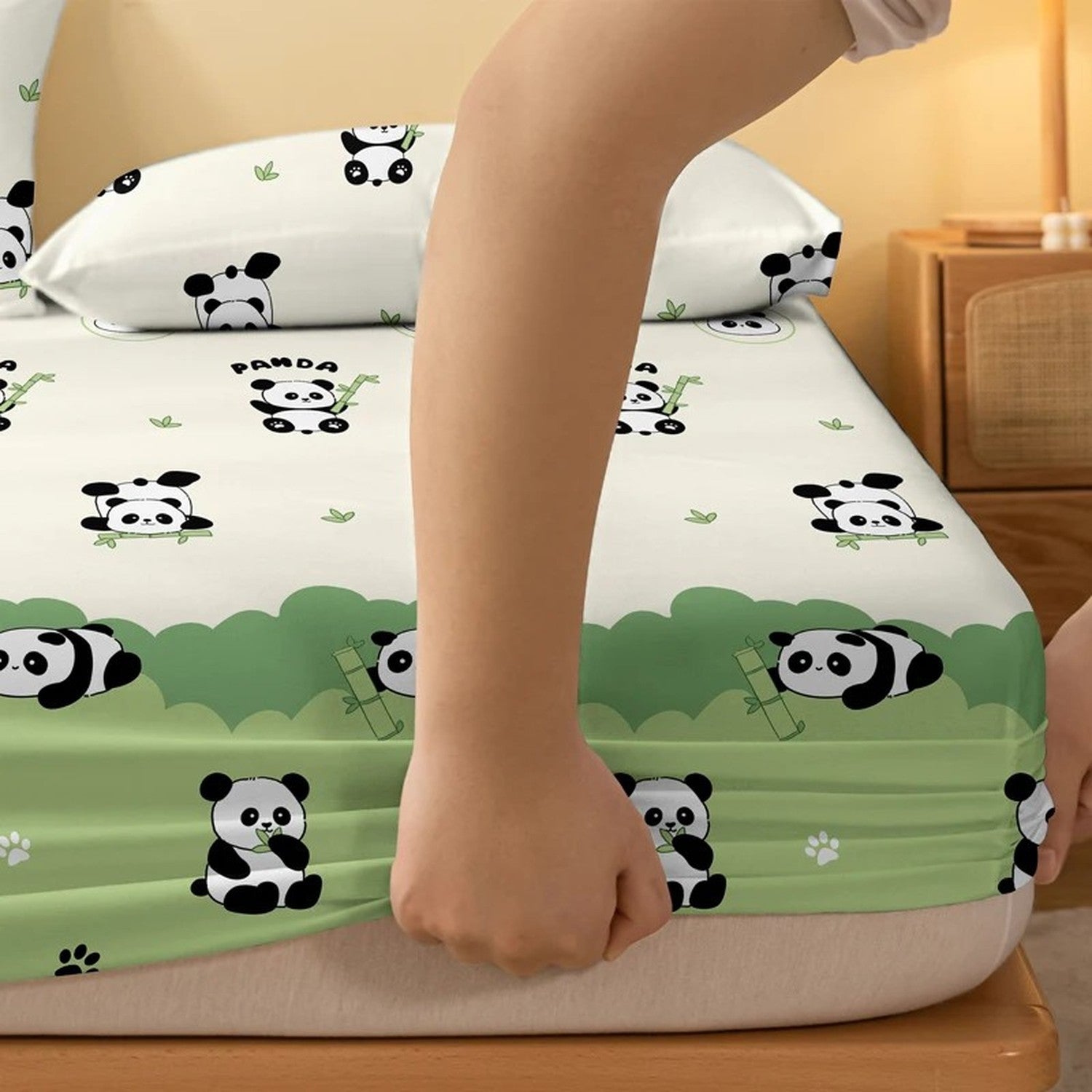 Coin élastiqué du drap-housse panda tendu à la main sur le matelas