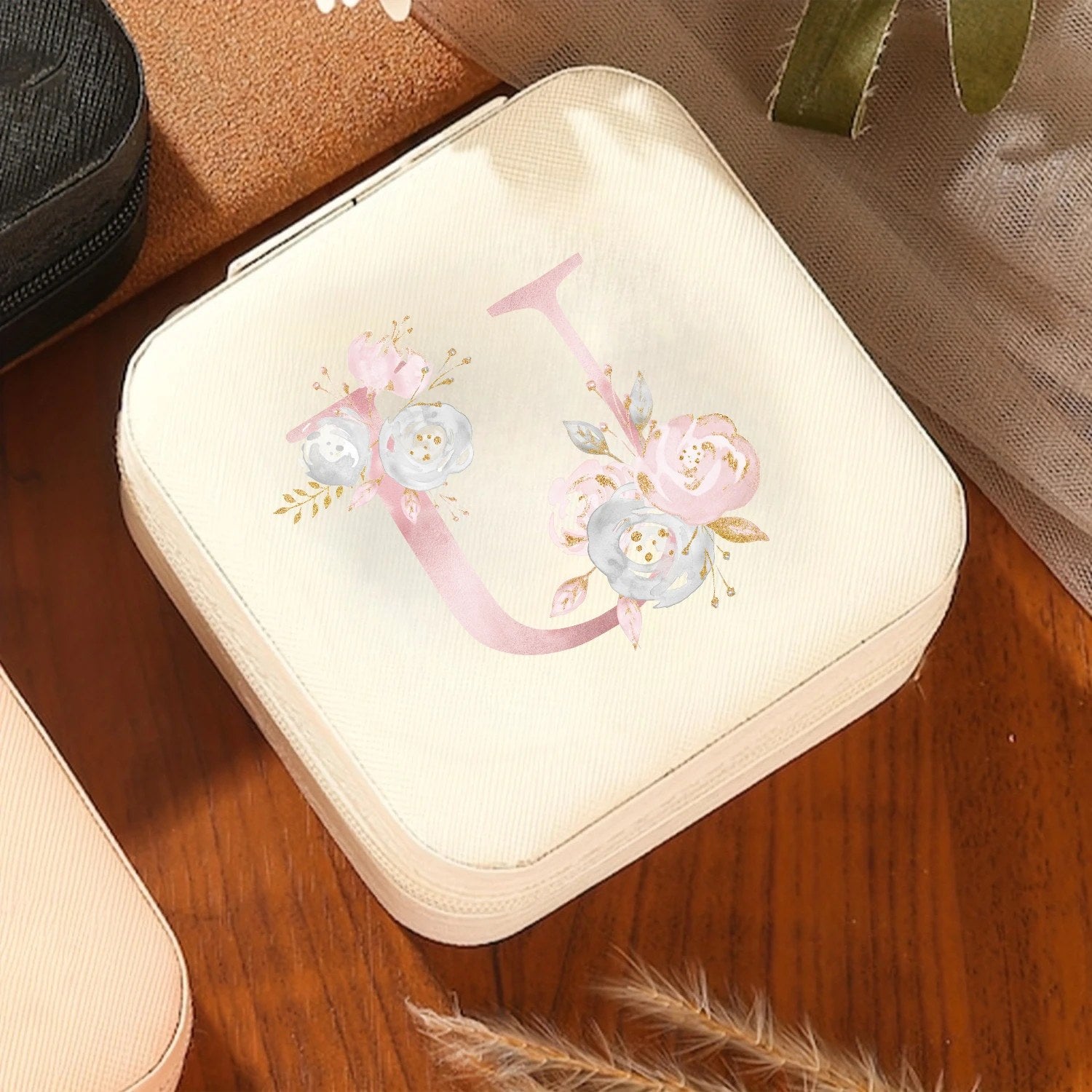 Boîte à bijoux initiale florale crème sur table en bois