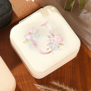 Boîte à bijoux initiale florale crème sur table en bois
