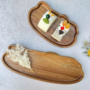 Plateaux en bois ovales avec des parts de gâteau et des pampas séchées