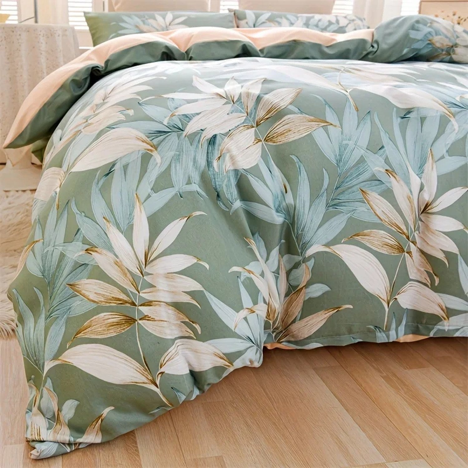Gros plan du motif feuilles tropicales blanc et vert de la housse de couette