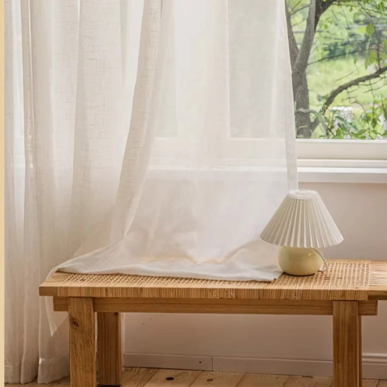 Voilage beige translucide drapé près d'une fenêtre ensoleillée
