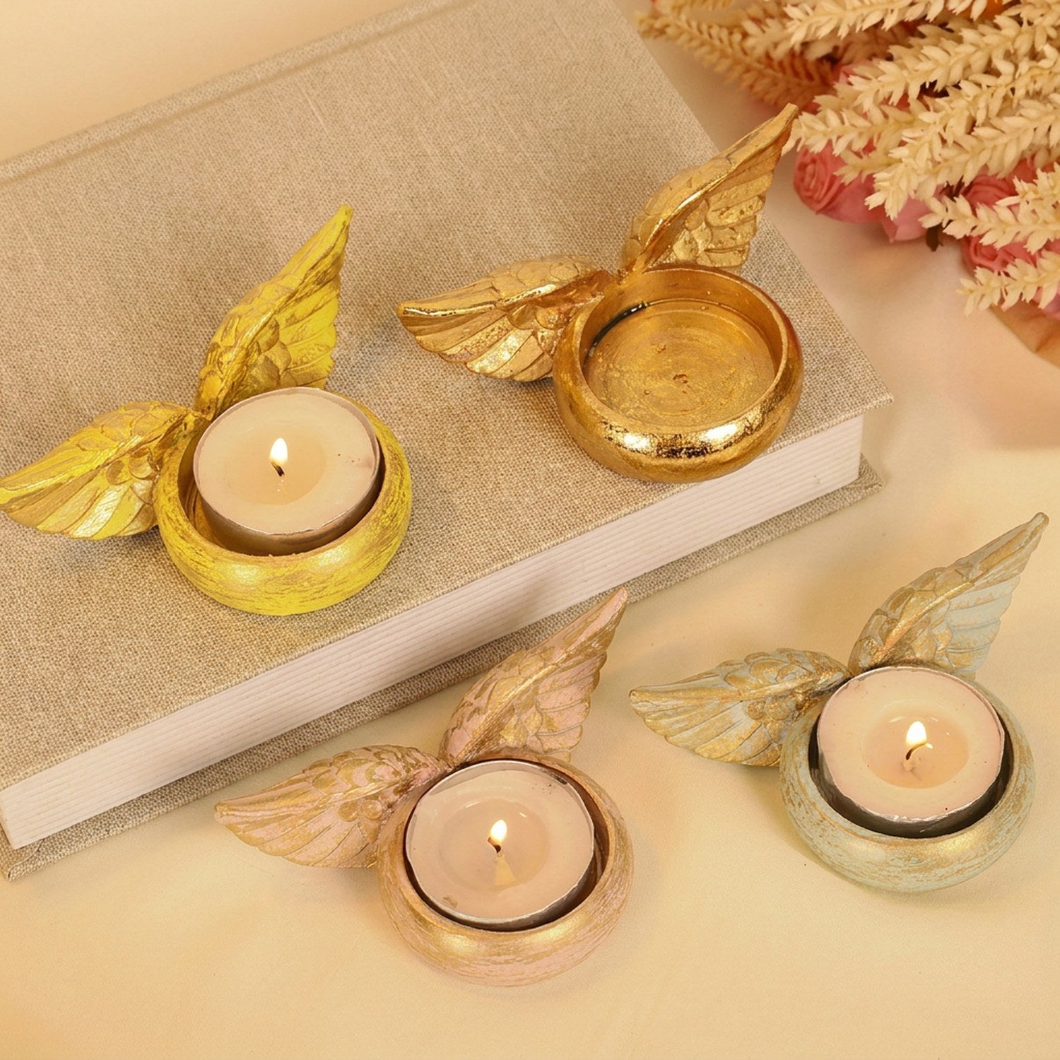 Bougeoir ailes d'ange en résine quatre couleurs avec bougies allumées mise en scène chaleureuse
