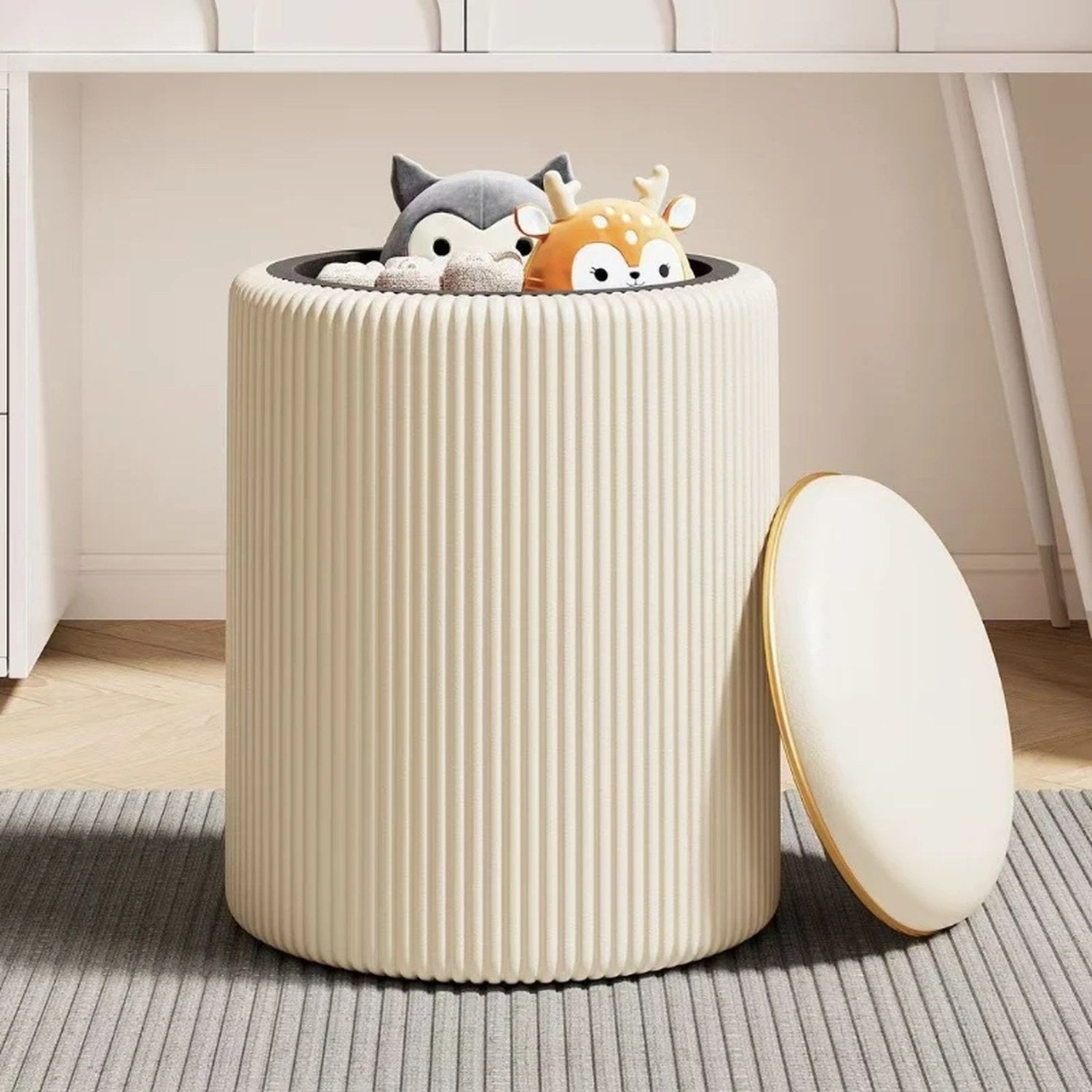 Tabouret de rangement beige ouvert rempli de peluches avec couvercle posé à côté