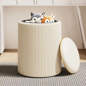 Tabouret de rangement beige ouvert rempli de peluches avec couvercle posé à côté