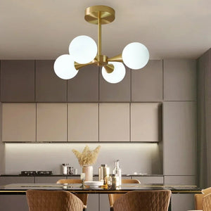Lustre art déco 4 globes opalins en bouquet au-dessus d'une table à manger en bois