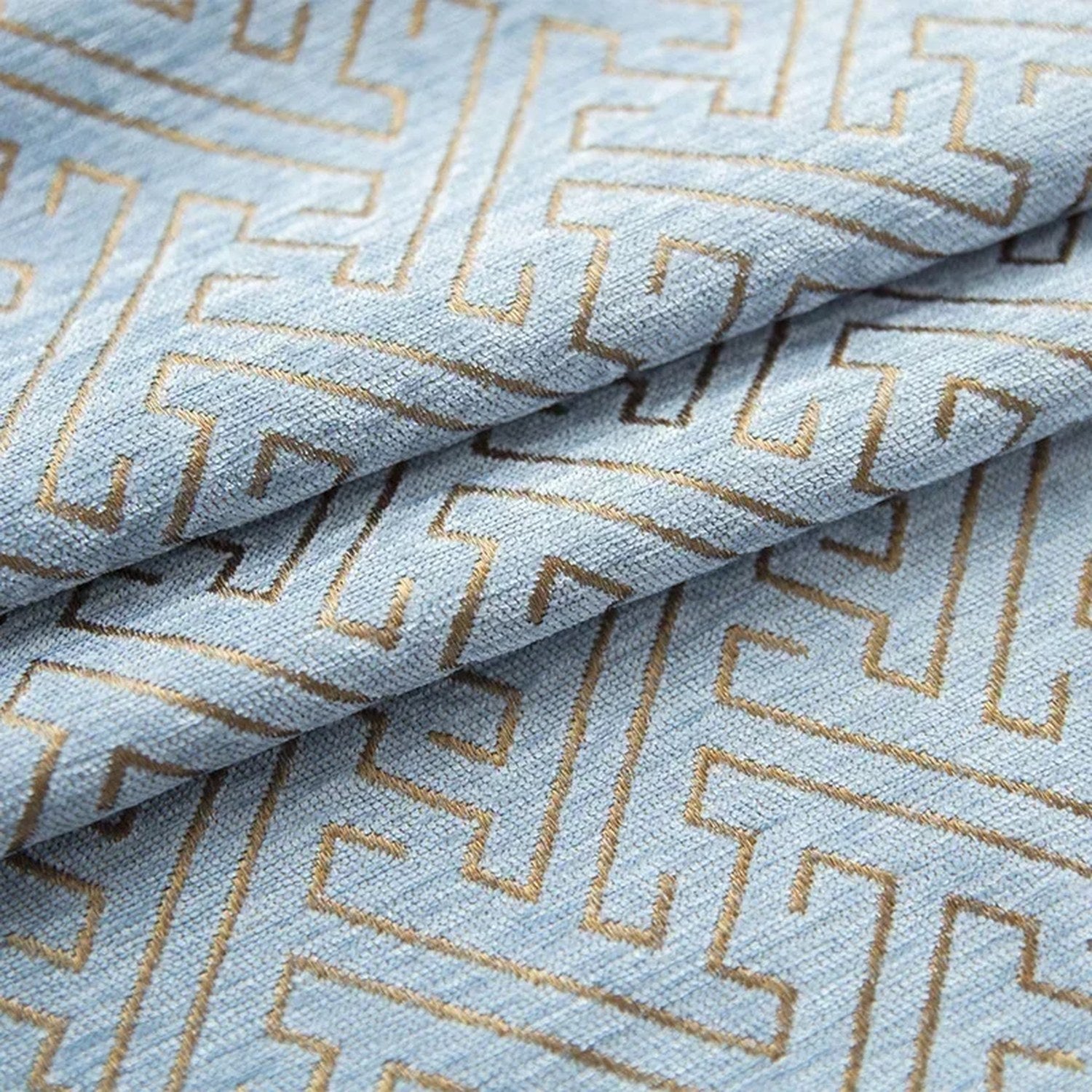 Gros plan du tissu chenille bleu clair avec motif géométrique doré