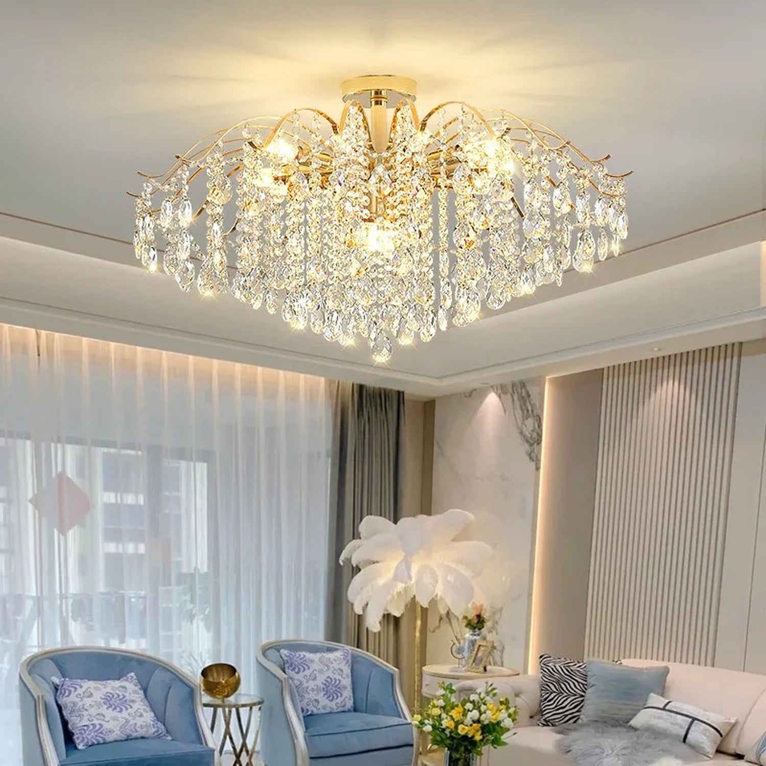 Lustre cristal doré au plafond d'un salon aux fauteuils bleus