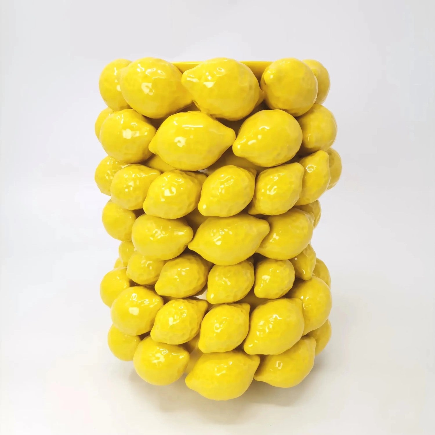 Vase citron en céramique jaune vu de près montrant les citrons en relief émaillés brillants