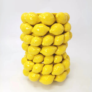 Vase citron en céramique jaune vu de près montrant les citrons en relief émaillés brillants