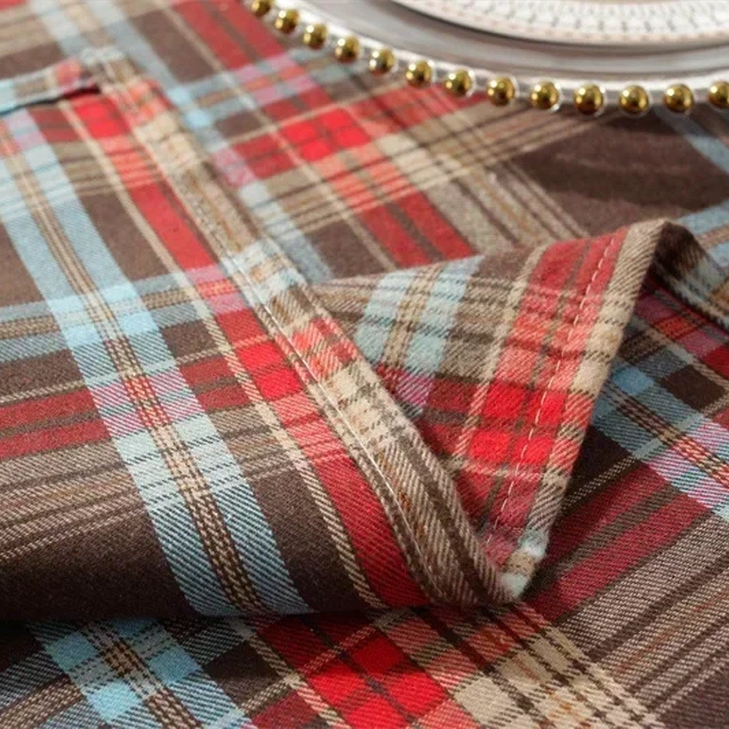 Gros plan sur le tissage à carreaux tartan d'une nappe de Noël