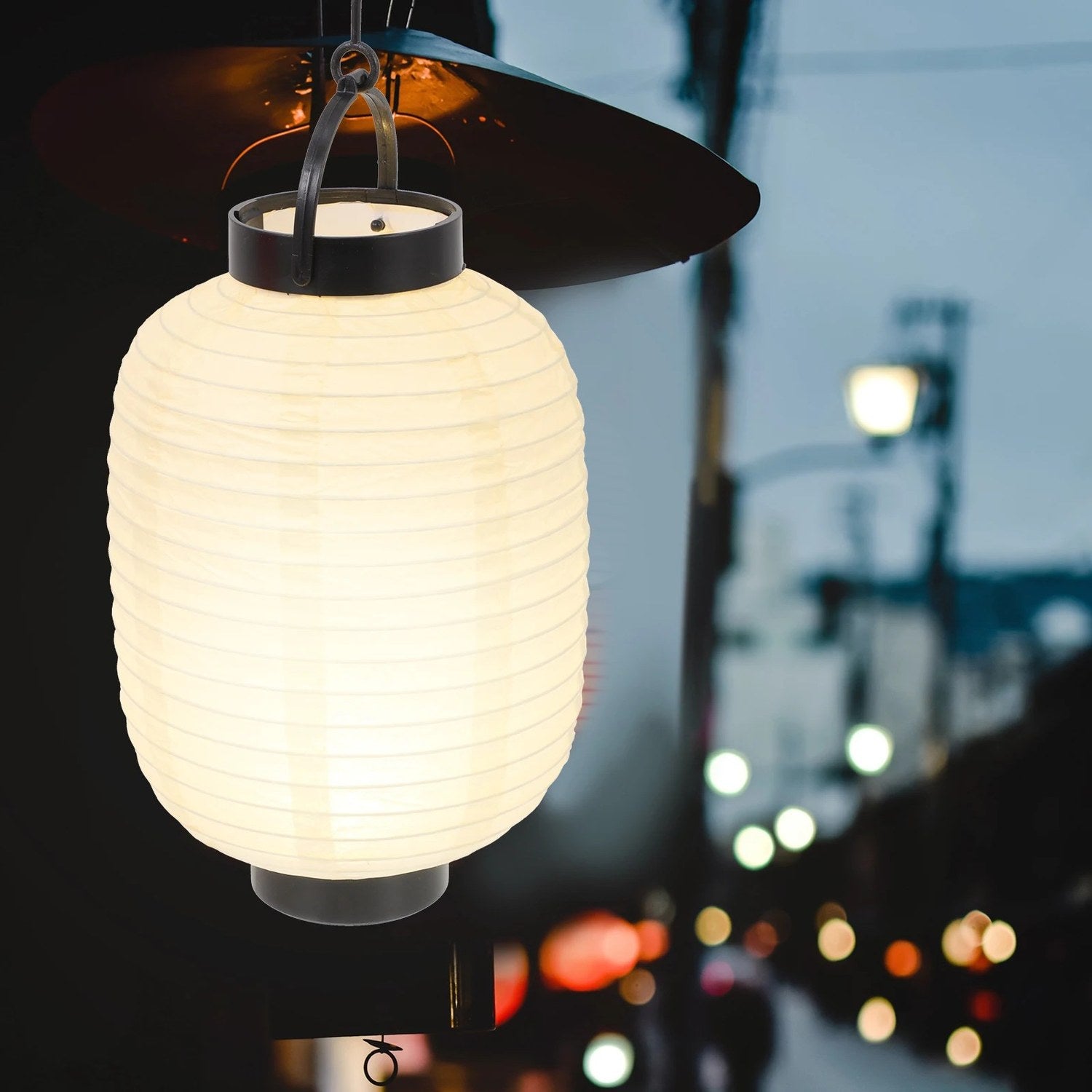 Lanterne japonaise en papier allumée en gros plan à la tombée de la nuit