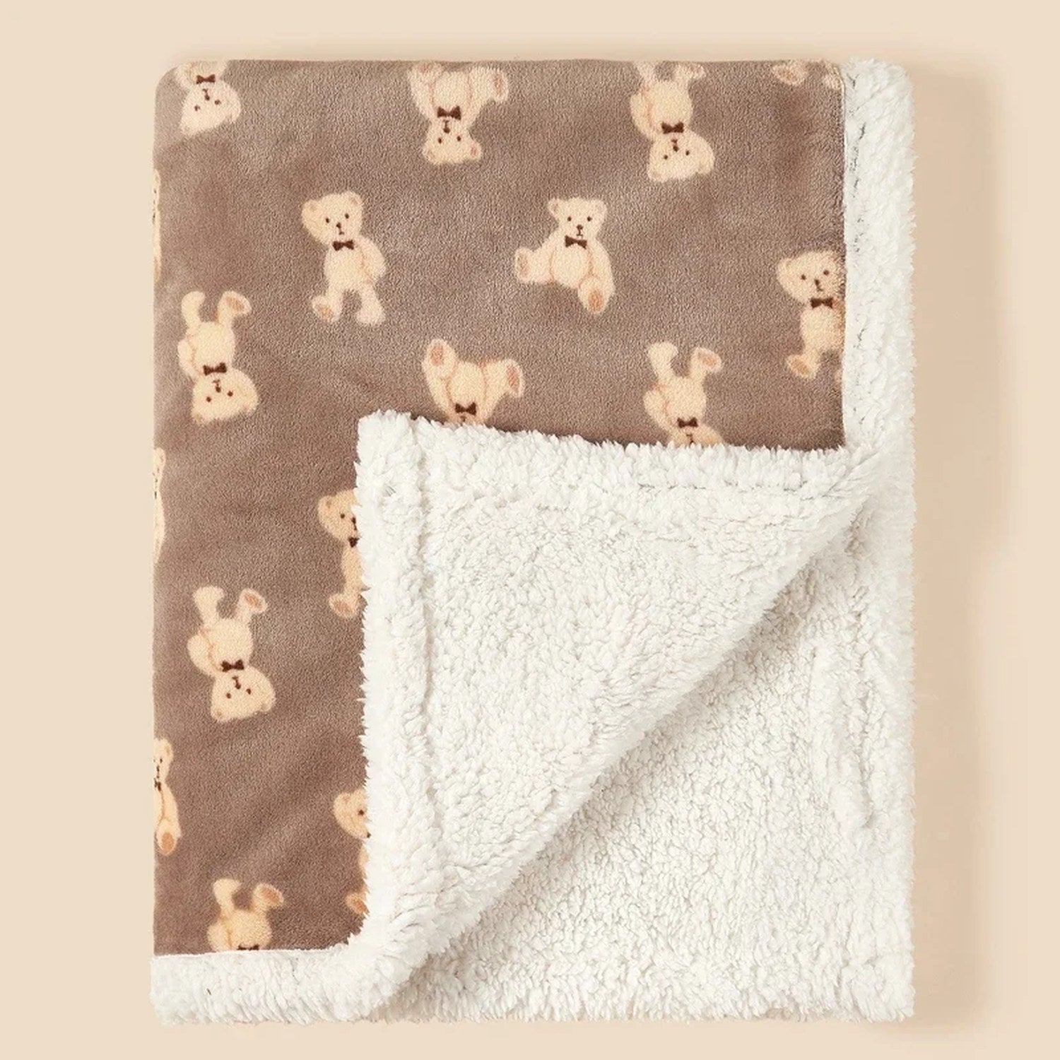 Détail de la couverture bébé motif ours café pliée avec doublure peluche blanche