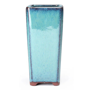 Pot de fleurs carré en céramique turquoise vu de face sur fond clair