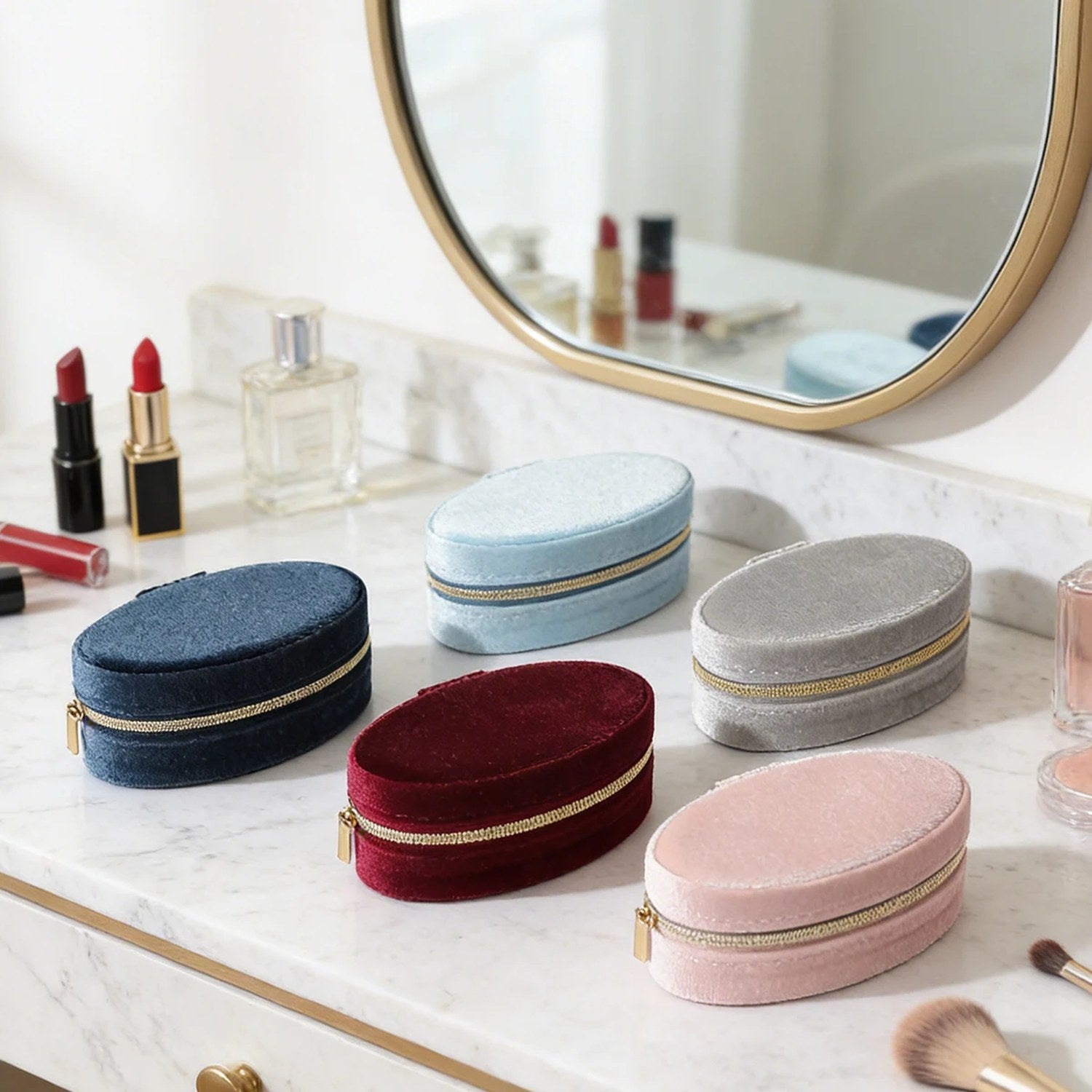 Cinq boîtes à bijoux en velours de couleurs différentes sur une coiffeuse