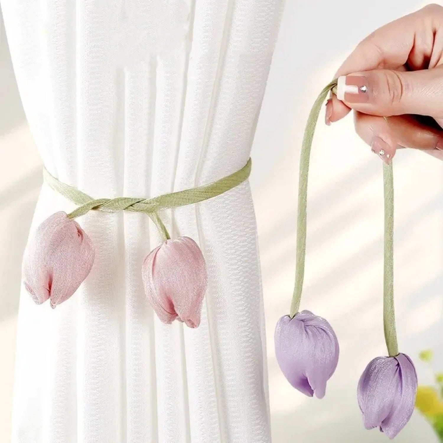 Embrasses de rideau tulipe rose et violet tenues a la main